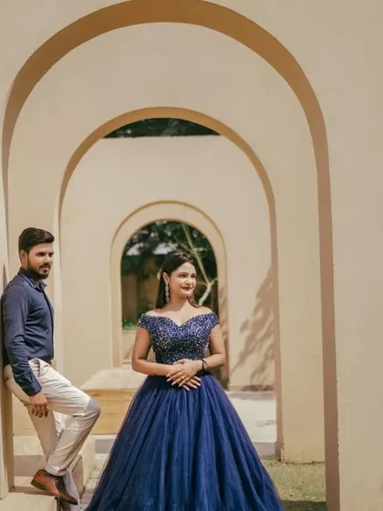 Our navy blue ball gown looks stunning against the clean lines of this modern architecture. The off-the-shoulder beaded bodice and full tulle skirt create a timelessly elegant look.