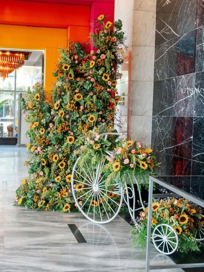 A charming welcome installation featuring a white bicycle overflowing with sunflowers. This rustic and cheerful decor piece is perfect for a daytime haldi or mehendi event.