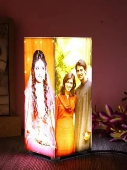 This personalized corner table lamp is designed to fit perfectly into any nook. It can display different photos on its two visible sides, offering a unique way to showcase your memories.