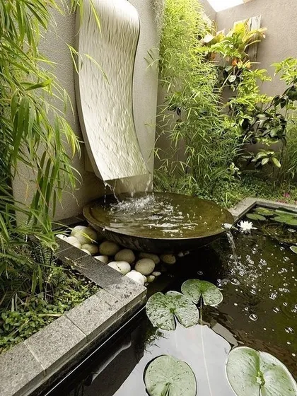 Landscaping is an art. This zen garden corner was designed around a sculptural, curved waterfall that creates a gentle sound as it flows into a basin and overflows into a small lily pond. The use of natural stone and bamboo completes the tranquil atmosphere.