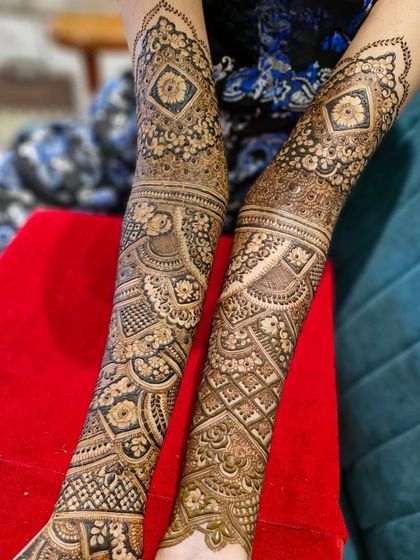 A close-up of the intricate arm work in a Dubai-style bridal mehendi, featuring a combination of geometric and floral patterns.