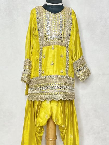 A traditional kurta and salwar set in bright yellow, heavily embellished with mirror work and gota patti. This is for the child with an Indian heart who loves classic designs.