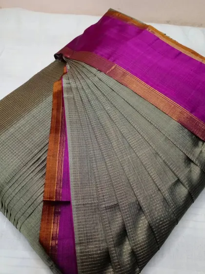 A sophisticated grey and magenta checked silk saree, pleated to fit the client's body type.