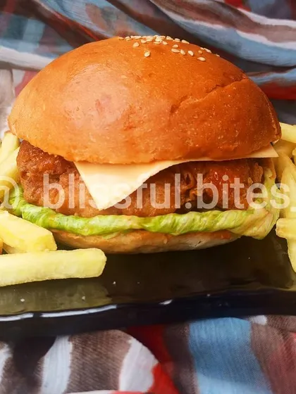 My popular Chicken Zinger Burger served as a complete meal with a generous portion of crispy french fries. A classic comfort food favorite.