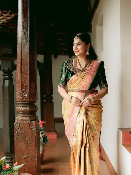 A full view of the bride in a traditional setting, showcasing the beautiful drape of her multi-hued silk saree.