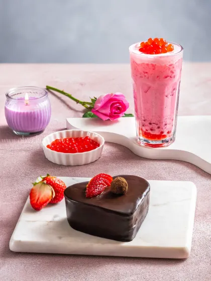 A Valentine's Day themed shot featuring a heart-shaped chocolate pastry and a strawberry bubble tea, creating a romantic mood.