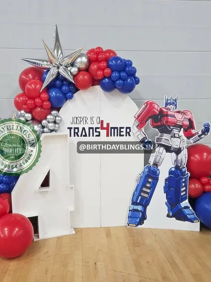 An action-packed Transformers party for a fourth birthday. The setup features a large Optimus Prime cutout, a custom number '4', and balloons in Autobot red and blue.