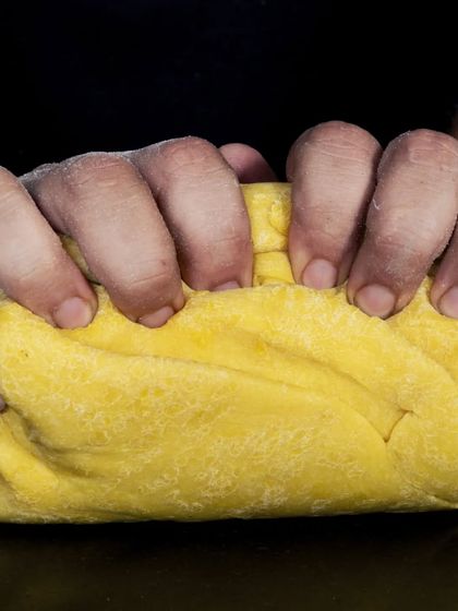 The process of making fresh pasta dough starts with the best ingredients. Here, I am kneading the rich, yellow dough that will become our handmade pasta.