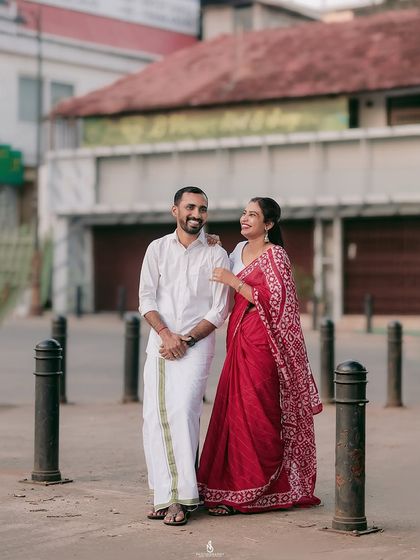 A beautiful portrait of a couple in traditional attire on a city street. The contrast between the traditional clothes and urban setting is striking.