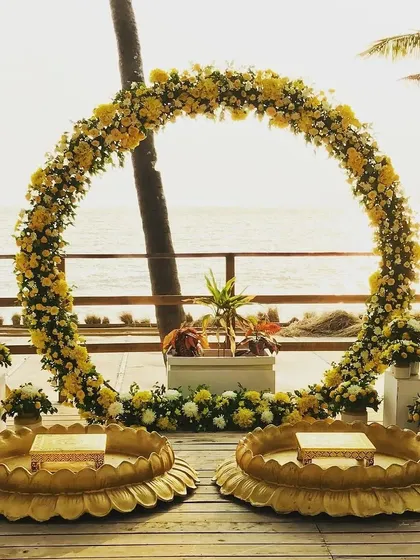 A beautiful Haldi ceremony setup right by the sea. I created this stunning floral ring arch and traditional 'urli' seating to blend perfectly with the natural beauty of the location, making for a truly memorable event.