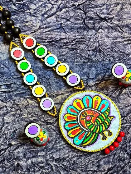 This version of the block-printed peacock necklace features a circular pendant and a silver-gray background. The chain has multi-colored discs that echo the colors in the peacock.
