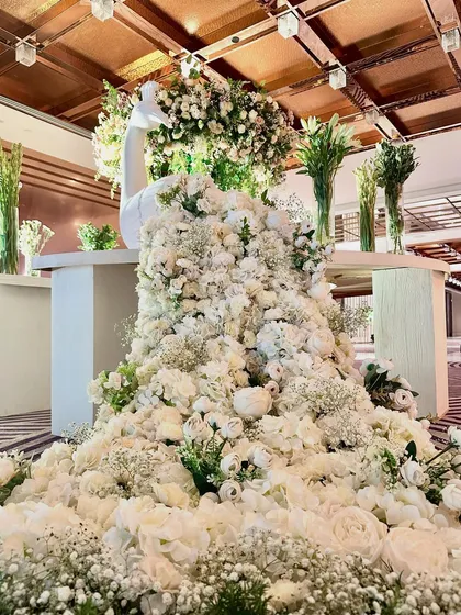 A magnificent floral peacock installation, with a cascade of white flowers forming its train. This statement piece serves as a stunning and artistic focal point for the event entrance.