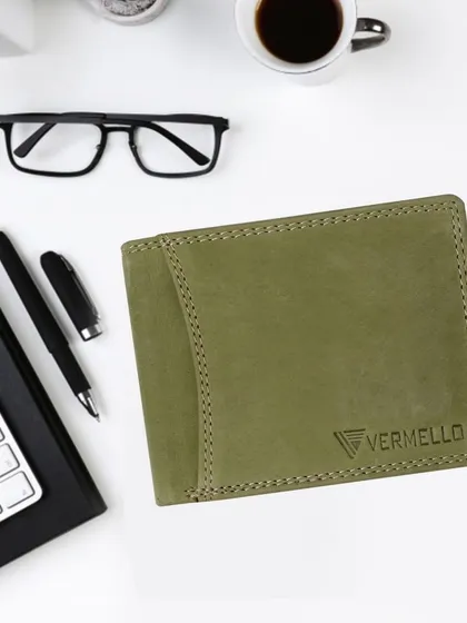 Our premium bifold wallet in a unique olive green genuine leather, displayed in a professional setting. The subtle embossed logo and fine stitching demonstrate our commitment to quality craftsmanship.