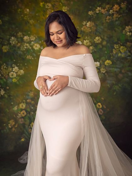 Making a heart shape on her bump, a simple and sweet expression of love for the little one inside.
