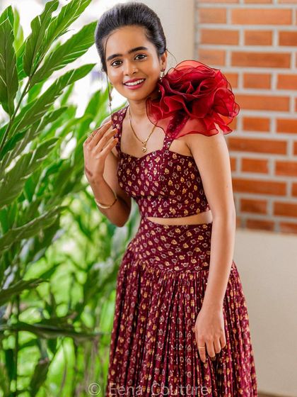 For Nisarga, I also created this beautiful maroon printed co-ord set. The pleated skirt gives it a wonderful twirl, and I added a dramatic ruffled organza flower on one shoulder for a touch of modern flair.