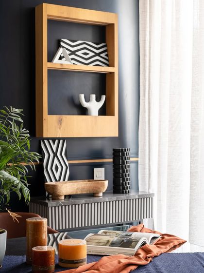 A close-up of the decor in Apartment 704, showing the fusion of raw materials and contemporary style. The design incorporates elements reflecting the clients' time in Africa, with bold patterns and natural textures.