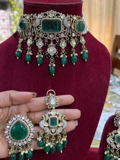 A luxurious emerald and Polki choker set, perfect for a high-end bridal or reception look.