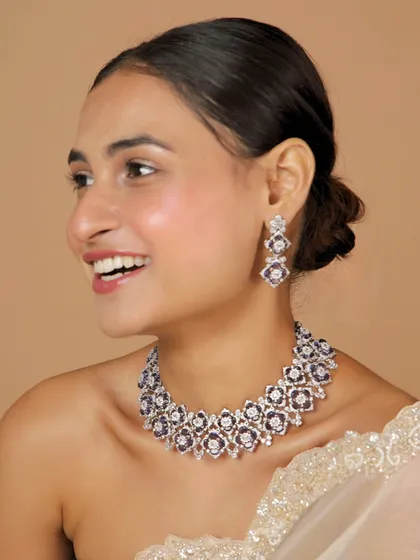 A smiling model showcases the beauty and elegance of our purple Polki diamond set. It's a perfect choice for someone who wants to add a pop of color to their formal wear.