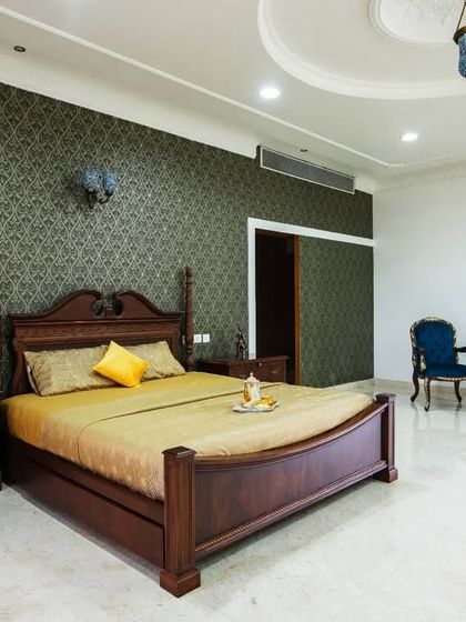 Another bedroom suite in the palace, this one featuring a four-poster bed and a darker, more intimate color palette with deep green wallpaper.
