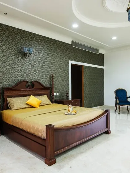 Another bedroom suite in the palace, this one featuring a four-poster bed and a darker, more intimate color palette with deep green wallpaper.