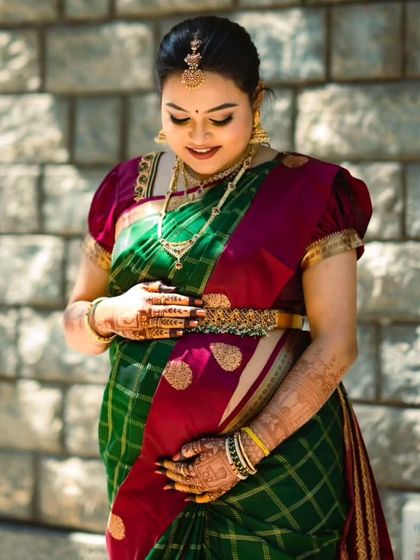 A full-length shot of Kruthika's baby shower look. The traditional saree and soft makeup come together to create a look of pure elegance.