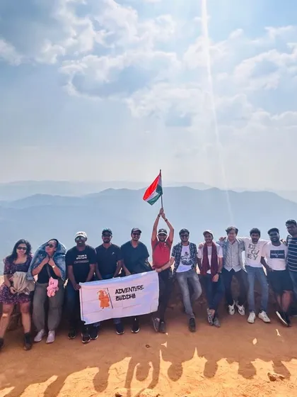 Our group at a viewpoint in Coorg, holding the Indian flag and our Adventure Buddha banner with pride.