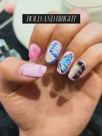 "Bold and Bright" nail art, featuring a butterfly, floral designs, and a marble effect, showcases the diverse range of techniques our students master.