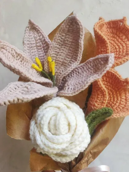 A bouquet that lasts forever. This arrangement features a mix of handmade crochet flowers, including delicate lilies and a classic white rose. It's a perfect, timeless gift for any occasion, bringing a touch of handmade beauty into your home without ever wilting.