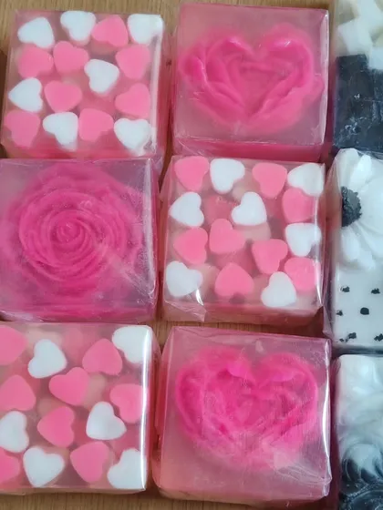 A collection of pink and white themed soaps, featuring hearts and roses. These are perfect for a romantic gift or wedding favor.