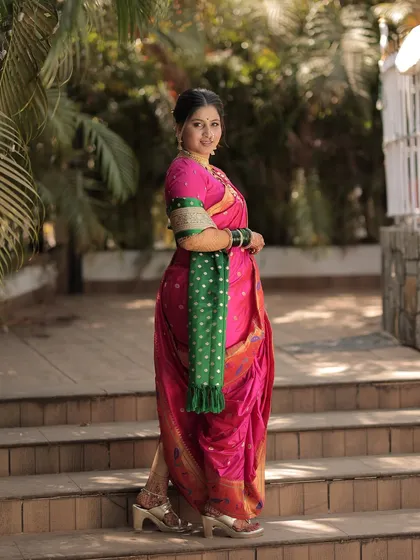 A full-length shot of the bride walking down the steps, showcasing the beautiful drape of her Nauvari saree.