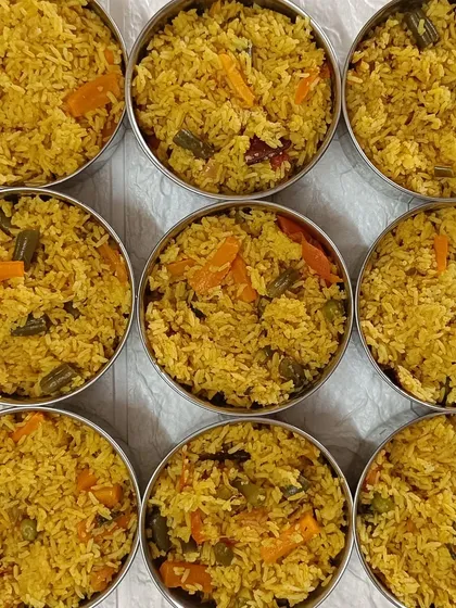 A top-down view of my Veg Pulao, with bowls packed and ready for delivery. It's loaded with fresh carrots, peas, and beans.