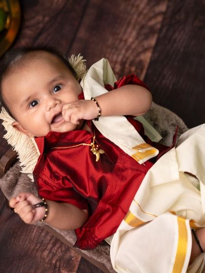 A sweet baby boy dressed in a traditional silk dhoti and shirt for a festive Ugadi-themed shoot, looking curious and happy.