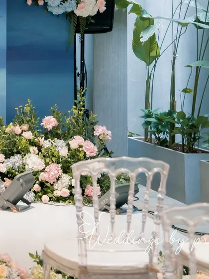 A detail shot of the Roka ceremony decor, showing the ghost chairs and the pastel floral arrangements. The design is minimal, modern, and very chic.
