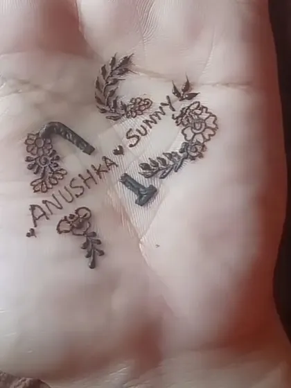 A heart-shaped initial design for Anushka and Sunny on the palm.