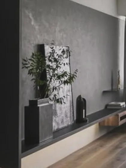 A close-up of a floating console we designed, focusing on the interplay of textures. The rough micro-concrete wall contrasts with the smooth wood of the console, creating a visually interesting detail.
