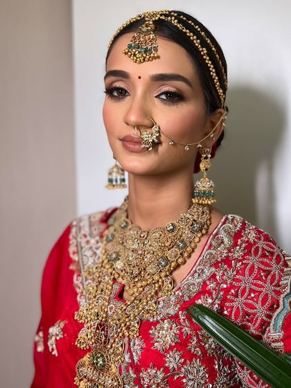 The bride looks stunning and regal with her traditional jewelry and classic hairstyle.