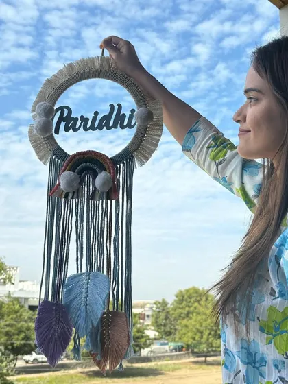Holding up the 'Paridhi' dreamcatcher. Each element is carefully crafted by hand to match the client's vision. We love bringing your custom ideas to life.