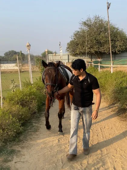 A rider leads his horse along a trail, showcasing the trust and partnership that is central to horsemanship.