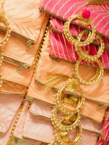 Thoughtful wedding favors for the Haldi ceremony. These beautiful potlis and gota bangles are arranged for guests to take, adding a traditional and personal touch.