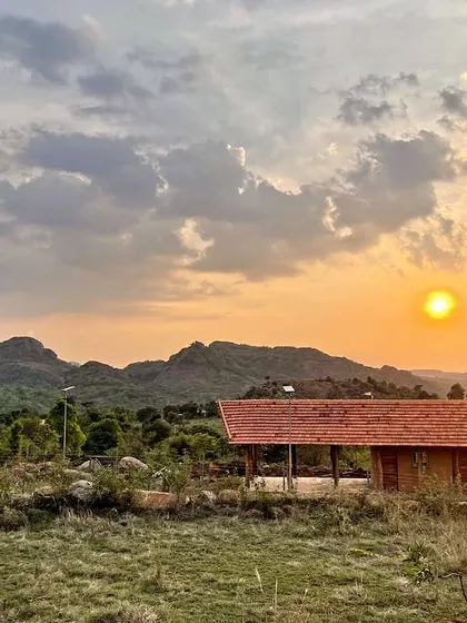 The Unnathi Farm pavilion at sunset, with the ancient Savanadurga monolith in the background. This project was about creating a simple, honest structure using recycled and natural materials, offering a space to connect with the land and find balance.