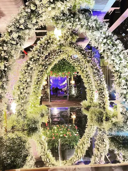 A stunning floral archway made entirely of baby's breath and white flowers, creating a dreamy, cloud-like entrance for an engagement party.