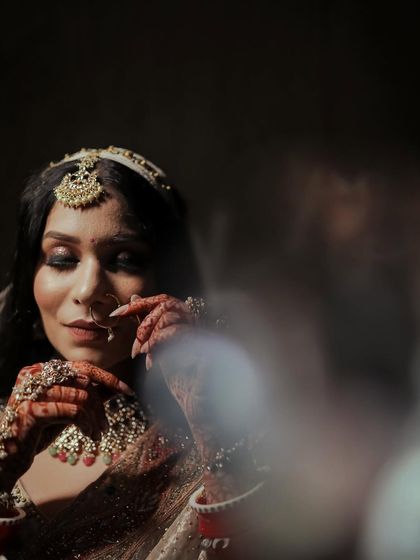 An artistic, through-the-glass shot of a bride getting ready.