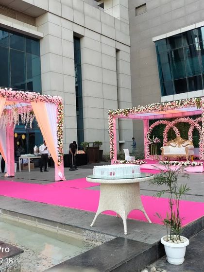 A view of the poolside wedding venue, showing the main stage and a separate, smaller mandap for other rituals.