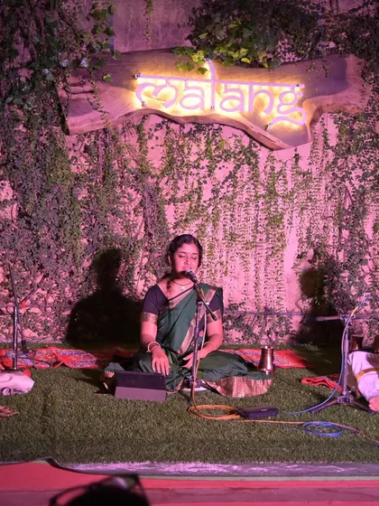 A performance at 'Malang' at Namma Ashram, with its beautiful green wall and neon sign creating a modern yet earthy ambiance for a classical concert.