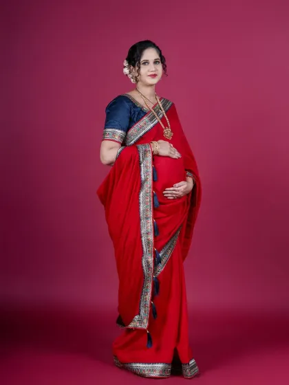 The elegance of tradition. This studio portrait shows a mother-to-be in a beautiful red saree, highlighting how I blend classic portraiture with cultural attire for a graceful and powerful maternity photo.