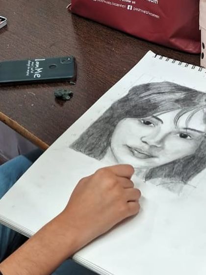 The artist at work on her portrait. Our classes provide a focused environment where students can immerse themselves in their projects and refine their pencil shading techniques.