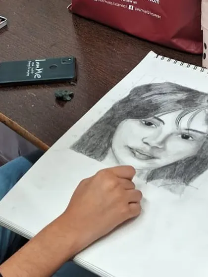 The artist at work on her portrait. Our classes provide a focused environment where students can immerse themselves in their projects and refine their pencil shading techniques.