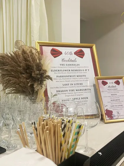 A stylish bar menu designed for a 40th birthday party. The elegant frame, custom cocktail names like "Lost in Litchi," and pampas grass decor all contribute to a chic and celebratory atmosphere.