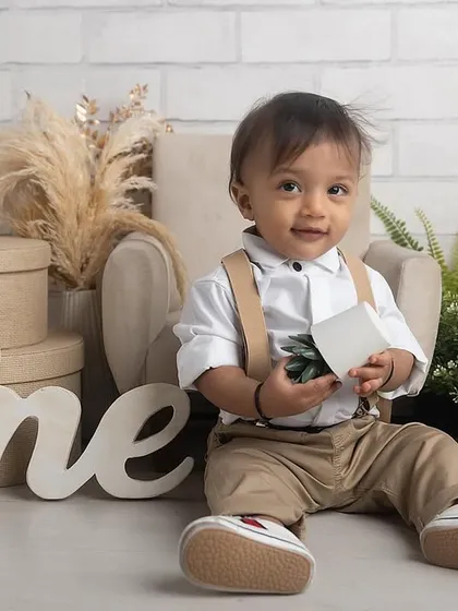 A handsome little gentleman celebrating his first birthday. This classic setup with neutral tones and natural elements is perfect for a timeless milestone portrait.