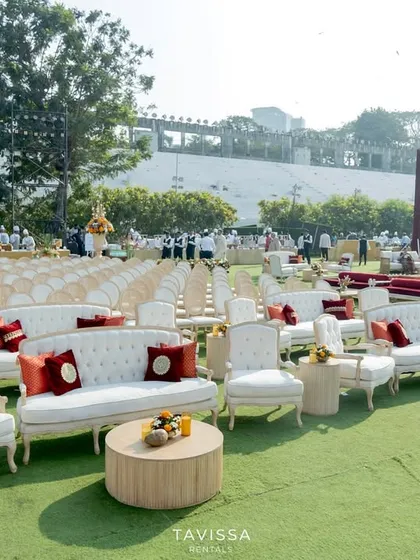 A mix of lounge and formal seating at a large outdoor wedding, with elegant white sofas providing a comfortable alternative to the ceremony chairs.